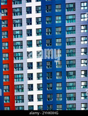 Farbenfrohe Hochhausfassade des Apartmentgebäudes mit gemusterten Fenstern Stockfoto