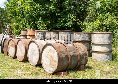Rostige alte Metallölfässer in Außenlagerung Stockfoto