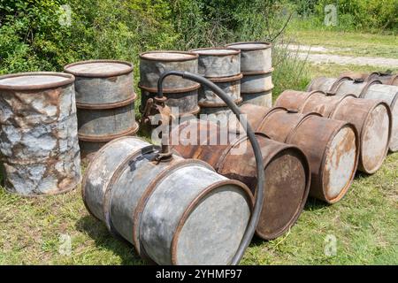 Rostige alte Metallölfässer in Außenlagerung Stockfoto