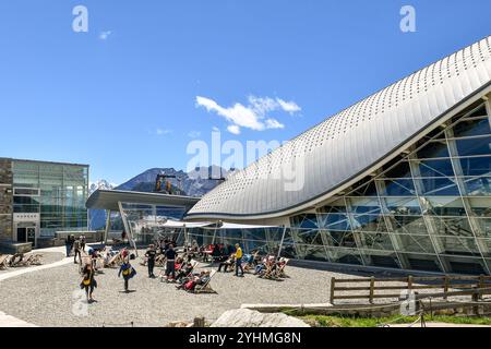 Wanderer ruhen und sonnen sich auf Liegestühlen vor der Seilbahnstation Pavillon (2173 m) des Skyway Monte Bianco im Sommer, Courmayeur, Italien Stockfoto