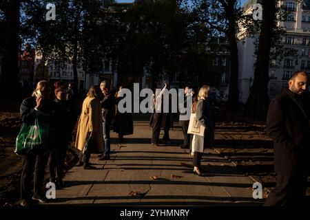 Stadtarbeiter genießen den letzten Winterabend, während sie am Berkeley Square, Mayfair, im Herzen des Londoner West End, England, standen Stockfoto