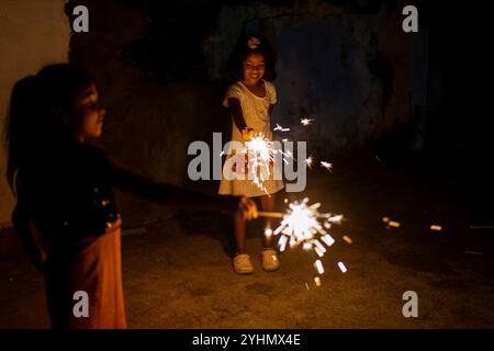 Zwei junge Mädchen erleuchten die Nacht mit Glitzern und schaffen eine magische Atmosphäre. Stockfoto