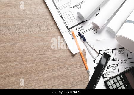 Verschiedene Architekturzeichnungen, Lineal, Bleistift, Taschenrechner und Trennwände auf Holztisch, flache Lagen. Leerzeichen für Text Stockfoto