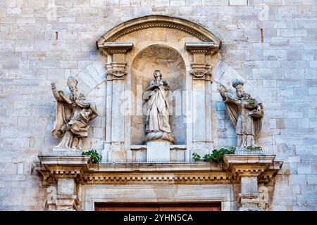 Romanische Statuen der Heiligen Nikolaus und Sabinus, zusammen mit der Himmelfahrt der Jungfrau Maria, schmücken das Hauptportal der Kathedrale von Bari in Italien Stockfoto