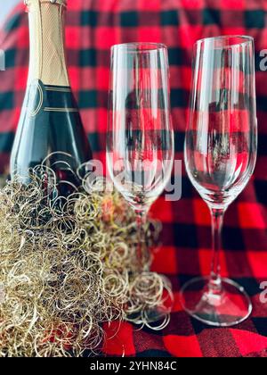 Weinbrille und Flasche Champagner auf rotem Hintergrund. Neujahrsfeier. Draufsicht. Flache Lagen. Stockfoto