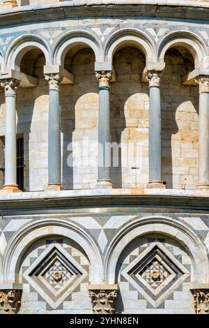 Nahaufnahme der romanischen Elemente des Schiefen Turms von Pisa, einschließlich Marmorsäulen, Bögen und dekorativen Arkaden, Italien Stockfoto