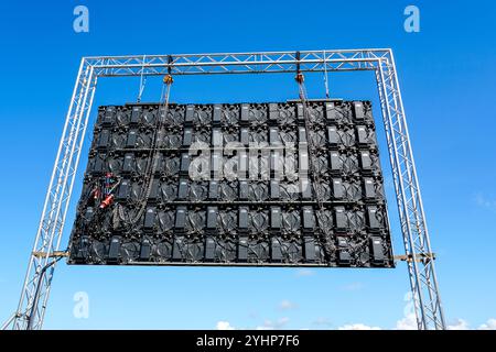 Große Ereignis-LED-Anzeige im Freien im Metallstrukturrahmen auf blauem Himmel Hintergrund, Rückansicht, Rückansicht der hochauflösenden LED-Videowände der Konzertbühne Stockfoto