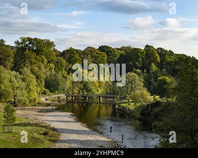 Besucher genießen Freizeitangebote (Wohlbefinden, Entspannung, Herbstsonne, Fußgängerbrücke) - das malerische Anwesen Bolton Abbey, Yorkshire Dales England, Großbritannien. Stockfoto