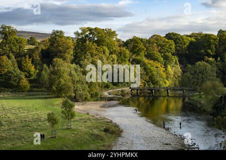 Besucher genießen Freizeitangebote (Wohlbefinden und Entspannung, Spaziergang am Ufer) - das malerische Anwesen Bolton Abbey, Yorkshire Dales, England, Großbritannien. Stockfoto