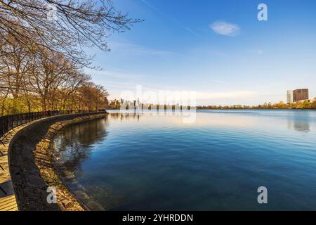 Ruhiger Blick auf das Jacqueline Kennedy Onassis Reservoir im Central Park am sonnigen Frühlingstag mit Reflexionen auf dem Wasser. New York. USA. Stockfoto