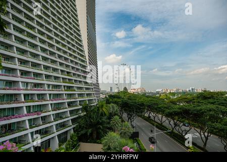 Ein Blick über Singapur mit einem Teil des Marina Bay Sands Hotel Balkons im Vordergrund mit Blick auf die Singapore Flyer Attraktion. Stockfoto