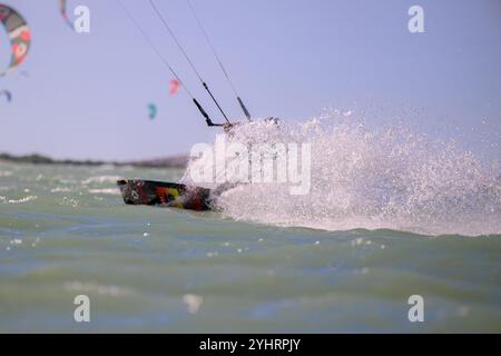 Doha Katar - 9. Mai 2024: Professioneller Kiter macht den schwierigen Trick vor einem wunderschönen Hintergrund. Kitesurfen Kiteboarding Action Fotos Mann unter Wabe Stockfoto