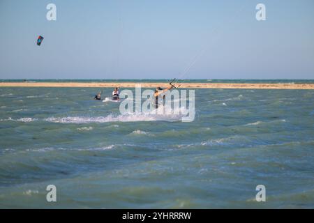 Doha Katar - 9. Mai 2024: Professioneller Kiter macht den schwierigen Trick vor einem wunderschönen Hintergrund. Kitesurfen Kiteboarding Action Fotos Mann unter Wabe Stockfoto