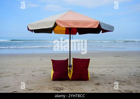 Pantai Kuta Beach mit Clourful Sonnenschirm im Sand mit Liegestühlen in Bali, Indonesien Stockfoto