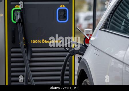 Elektroauto lädt an einer Ökostrom-Ladestation 12.11.24, Rüsselsheim: Symbolfoto, Illustrationsbild, Symbolbild, Illustrationsfoto, Alltagsszene Elektroauto lädt an einer Ökostrom-Ladestation ein Elektroauto beim Laden an einer Ladestation mit der Aufschrift 100% Ökostrom. Der Ladestecker ist mit dem Fahrzeug verbunden und zeigt den Einsatz erneuerbarer Energiequellen. . . Rüsselsheim Hessen Deutschland *** Elektroauto-Aufladung an einer Ökostrom-Ladestation 12 11 24, Rüsselsheim Symbolfoto, Illustrationsbild, Symbolbild, Illustrationsfoto, Alltagsszene Elektroauto aufladen bei A Stockfoto
