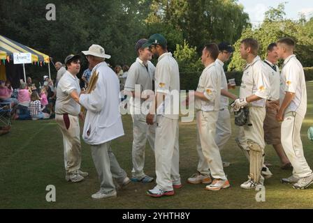 Hände schütteln am Ende des Dorfes Cricketspiels. Zwei gegnerische Mannschaften, die sich gegenseitig anerkennen und ein Gefühl von Kameradschaft zeigen. Eine Geste, die dazu beiträgt, den Geist des Fairplay und des gegenseitigen Respekts zu wahren. Der Schiedsrichter trägt die Grillen-Wicket-Stümpfe. Village Life Sussex England 2015 UK 2000s HOMER SYKES Stockfoto