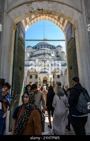 24/10/2024. Die Blaue Moschee, Istanbul, Türkei. Besucher betreten und verlassen den Innenhof. Die Blaue Moschee, offiziell Sultan Ahmed Moschee (türkisch Sultan Ahmet Camii), ist eine historische Moschee aus der osmanischen Zeit in Istanbul. Sie wurde zwischen 1609 und 1617 unter der Herrschaft von Ahmed I. errichtet und ist heute noch eine funktionierende Moschee. Es zieht auch eine große Anzahl von Touristen an und ist eines der bekanntesten und beliebtesten Denkmäler der osmanischen Architektur. Die Moschee hat einen klassischen osmanischen Grundriss mit einer zentralen Kuppel, die von vier Halbkuppeln über dem Gebetssaal umgeben ist. Es ist Fronte Stockfoto