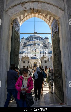 24/10/2024. Die Blaue Moschee, Istanbul, Türkei. Besucher betreten und verlassen den Innenhof. Die Blaue Moschee, offiziell Sultan Ahmed Moschee (türkisch Sultan Ahmet Camii), ist eine historische Moschee aus der osmanischen Zeit in Istanbul. Sie wurde zwischen 1609 und 1617 unter der Herrschaft von Ahmed I. errichtet und ist heute noch eine funktionierende Moschee. Es zieht auch eine große Anzahl von Touristen an und ist eines der bekanntesten und beliebtesten Denkmäler der osmanischen Architektur. Die Moschee hat einen klassischen osmanischen Grundriss mit einer zentralen Kuppel, die von vier Halbkuppeln über dem Gebetssaal umgeben ist. Es ist Fronte Stockfoto