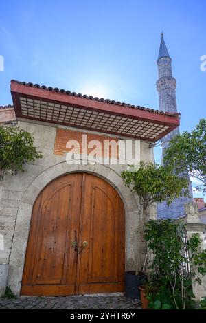 10/2024. Istanbul, Türkei. Ein Tor in der Mauer der Hagia Sophia auf Soğukçeşme Sokağı (wörtlich: Straße des kalten Brunnens) ist eine kleine Straße mit historischen Häusern im Stadtteil Sultanahmet in Istanbul, Türkei, zwischen der Hagia Sophia und dem Topkapı-Palast. Die autofreie Zone ist nach dem Brunnen benannt, der sich am Ende in Richtung Gülhane Park befindet. Die hölzernen, zwei- oder dreistöckigen osmanischen Häuser, die aus vier bis zehn Räumen bestehen, stammen aus dem 19. Bis 20. Jahrhundert und wurden auf Initiative von Celik Gülersoy in den Jahren 1985–1986 restauriert, Foto: © Simon Grosset Stockfoto