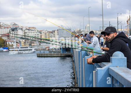 25/10/2024. Istanbul, Türkei. Fischer auf der Galata-Brücke, die von der türkischen Baugesellschaft STFA nur wenige Meter von der vorherigen Brücke entfernt zwischen Karaköy und Eminönü gebaut und im Dezember 1994 fertiggestellt wurde. Es handelt sich um eine Klappbrücke mit einer Länge von 490 m (1.610 ft) und einer Hauptspannweite von 80 m (260 ft). Das Deck der Brücke ist 42 m (138 ft) breit und hat zwei Fahrzeugspuren und einen Gehweg in jede Richtung. Die in der Mitte verlaufenden Straßenbahngleise erlauben es der Straßenbahn T1, von Bağcılar im westlichen Vorort nach Kabataş zu fahren. 2003 wurde eine Reihe von Restaurants zu den Unders hinzugefügt Stockfoto