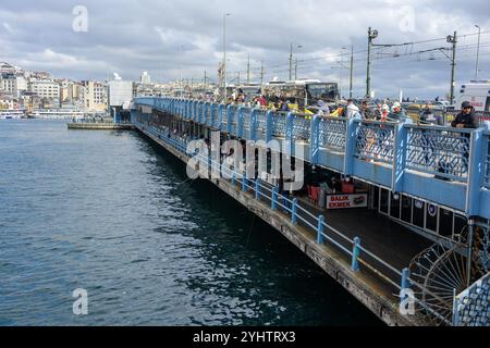 25/10/2024. Istanbul, Türkei. Fischer auf der Galata-Brücke, die von der türkischen Baugesellschaft STFA nur wenige Meter von der vorherigen Brücke entfernt zwischen Karaköy und Eminönü gebaut und im Dezember 1994 fertiggestellt wurde. Es handelt sich um eine Klappbrücke mit einer Länge von 490 m (1.610 ft) und einer Hauptspannweite von 80 m (260 ft). Das Deck der Brücke ist 42 m (138 ft) breit und hat zwei Fahrzeugspuren und einen Gehweg in jede Richtung. Die in der Mitte verlaufenden Straßenbahngleise erlauben es der Straßenbahn T1, von Bağcılar im westlichen Vorort nach Kabataş zu fahren. 2003 wurde eine Reihe von Restaurants zu den Unders hinzugefügt Stockfoto