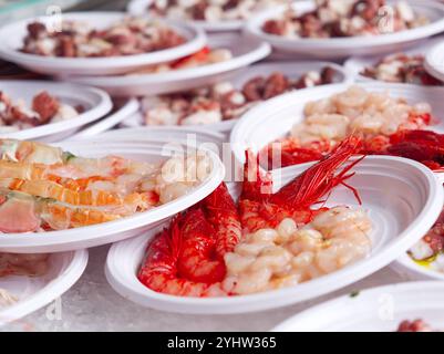 Frische Meeresfrüchte serviert auf Plastiktellern, Foto. Straßenmarkt in Catania, Sizilien. Stockfoto