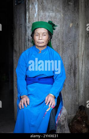 Hmong-Frau, die vor ihrem Haus in der Nähe von Dong Van in der Provinz Ha Giang in Vietnam sitzt Stockfoto