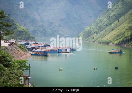 Touristenboote auf dem Fluss Nho Que in der Provinz Ha Giang, Nordvietnam. Der Fluss schlängelt sich durch die hohen Kalksteinklippen des Dong Van Karst Stockfoto