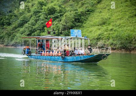 Ein Touristenboot auf dem Fluss Nho Que in der Provinz Ha Giang, Vietnam. Der Fluss schlängelt sich durch die Kalksteinklippen des Geoparks Dong Van Karst Plateau Stockfoto