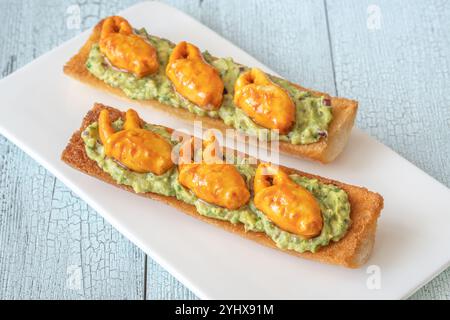 Toast mit Avocado-Guacamole und Krabbenkrallen Stockfoto