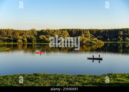 Malerischer Blick auf die Donau bei Sonnenuntergang mit zwei Fischerbooten und wunderschönen Reflexen von Bäumen auf der Wasseroberfläche, Serbien Stockfoto
