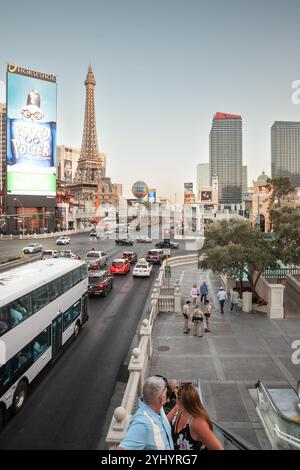 LAS VEGAS, 21. AUGUST 2024: Der Verkehr bewegt sich entlang des Las Vegas Strip (Las vegas Boulevard), während Touristen die Rolltreppen hinaufsteigen, mit Paris Las Vegas & Stockfoto