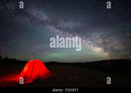 Milchstraße, die bogenförmig über den Nachthimmel mit Airglow oben ein Zelt, Bridger-Teton National Forest, Wyoming Stockfoto