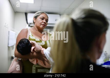 Monte Alegre, Brasilien. November 2023. Eine besorgte Patientin bringt ihr Kind zu einer pädiatrischen Beratung im Papst-Franziskus-Krankenhaus-Boot. In Monte-Alegre, Brasilien, mitten im Amazonas-Regenwald, trifft das von der Brüderschaft des Heiligen Franziskus von Assisi in der Vorsehung Gottes gegründete und geführte Krankenhaus-Boot des Papst Franziskus auf die lokalen Bewohner, um den Mangel an Gesundheitsinfrastruktur in einer vom Bergbau und den Auswirkungen des Klimawandels geprägten Region auszugleichen. (Foto: Apolline Guillerot-Malick/SOPA Images/SIPA USA) Credit: SIPA USA/Alamy Live News Stockfoto