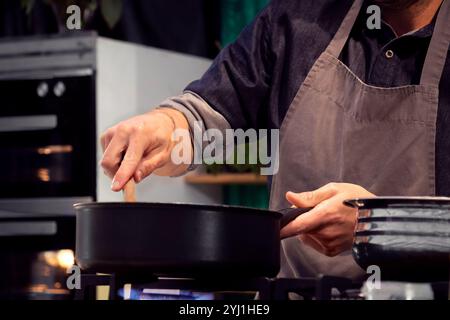 Küchenchef kocht und bereitet Zutaten im Restaurant vor. Ein professioneller Koch und Handwerker, der in der Zubereitung von Speisen gut vertraut ist. Stockfoto