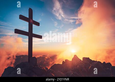 Sonnenuntergang über Krivan in der Hohen Tatra mit dem Doppelkreuz auf dem berühmten Berg der Slowakei, einem majestätischen Symbol der Nation Stockfoto