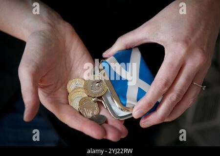 Aktenfoto vom 04/18 von Münzen in einer Saltyre-Tasche. Kurzfristige Finanzierungszyklen schaffen finanzielle Instabilität für Wohltätigkeitsorganisationen in Schottland, so der Bericht des Ausschusses für soziale Gerechtigkeit und soziale Sicherheit vor dem Haushaltsplan der MSPs. Erscheinungsdatum: Mittwoch, 13. November 2024. Stockfoto