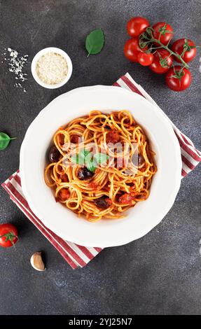 Spaghetti alla puttanesca oder neapolitanische Nudeln auf grauem Hintergrund. Italienische Küche. Draufsicht. Stockfoto