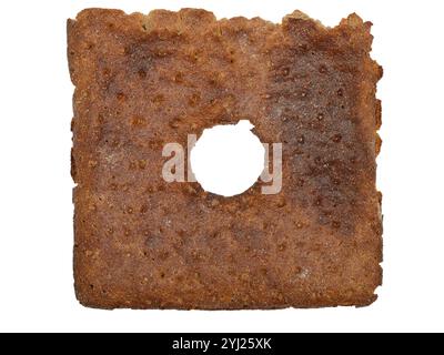 Dieses Bild zeigt ein einzelnes Stück traditionelles finnisches Roggenbrot, bekannt als „Reikäleipä“, das sich durch seine dunkelbraune Farbe, die grobe Textur und auszeichnet Stockfoto