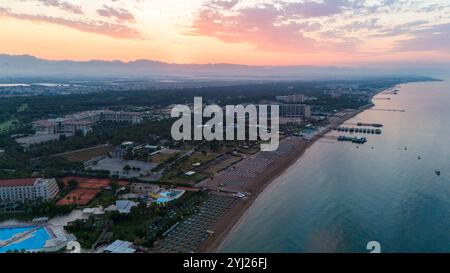 Ein atemberaubender Sonnenuntergang über einem luxuriösen Strandresort, der die ruhige Schönheit der Küste einfängt, wenn der Tag vergeht. Stockfoto