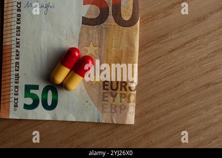 Antibiotikakapseln auf einer Banknote platziert, symbolisieren die hohen Kosten von Medikamenten und Gesundheitsversorgung. Stockfoto