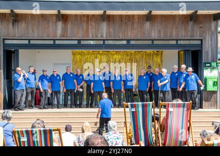 Der Newquay Male Voice Choir tritt im Freien auf der Bühne in Killacourt, Newquay, Cornwall, England, Großbritannien auf Stockfoto