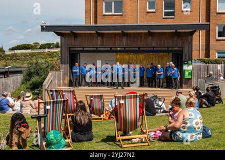 Der Newquay Male Voice Choir tritt im Freien auf der Bühne in Killacourt, Newquay, Cornwall, England, Großbritannien auf Stockfoto