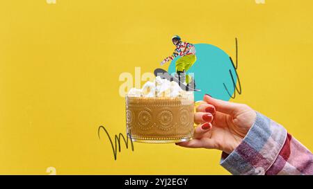 Eine Tasse heiße Schokolade mit Schlagsahne und einem kleinen Snowboarder reitet auf der Creme. Wintersport extrem. Zeitgenössische Kunstcollage. Stockfoto