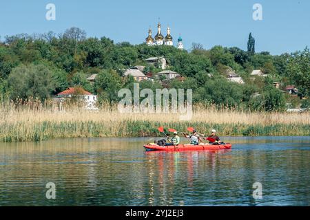 Ukraine, die Stadt Romny, 22. Mai 2021: Eine Gruppe glücklicher Menschen fährt mit dem Kajak auf dem Fluss. Konzept des Welttourismus-Tages. Aktiver Lebensstil. Stockfoto