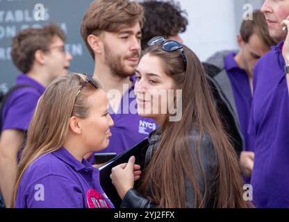 Im Spätsommer in Framlingham Suffolk gibt der National Youth Choir of Great Britain in passenden lila Poloshirts ein Konzert im Freien auf dem Markt Stockfoto