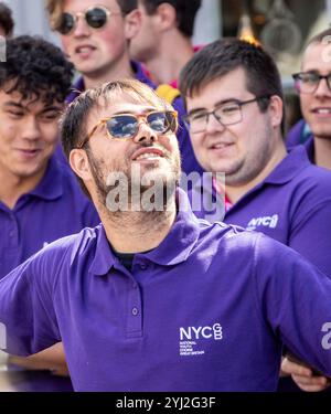 Im Spätsommer in Framlingham Suffolk gibt der National Youth Choir of Great Britain in passenden lila Poloshirts ein Konzert im Freien auf dem Markt Stockfoto