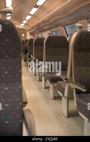 Leerer Zugwagen mit Sitzreihen und Deckenbeleuchtung. Stockfoto