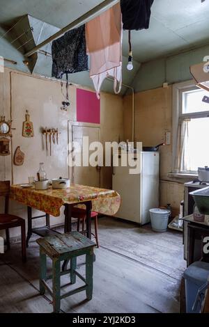 Das Innere der alten schmutzigen Küche mit trockener Kleidung unter der Decke Stockfoto