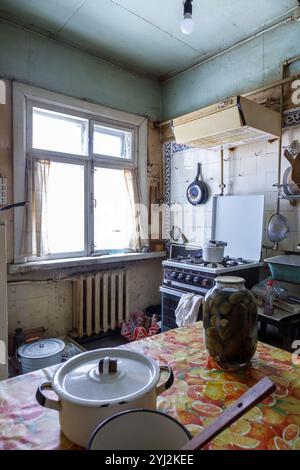 Das Innere der alten schmutzigen Küche mit veralteten Möbeln und Haushaltsgegenständen Stockfoto